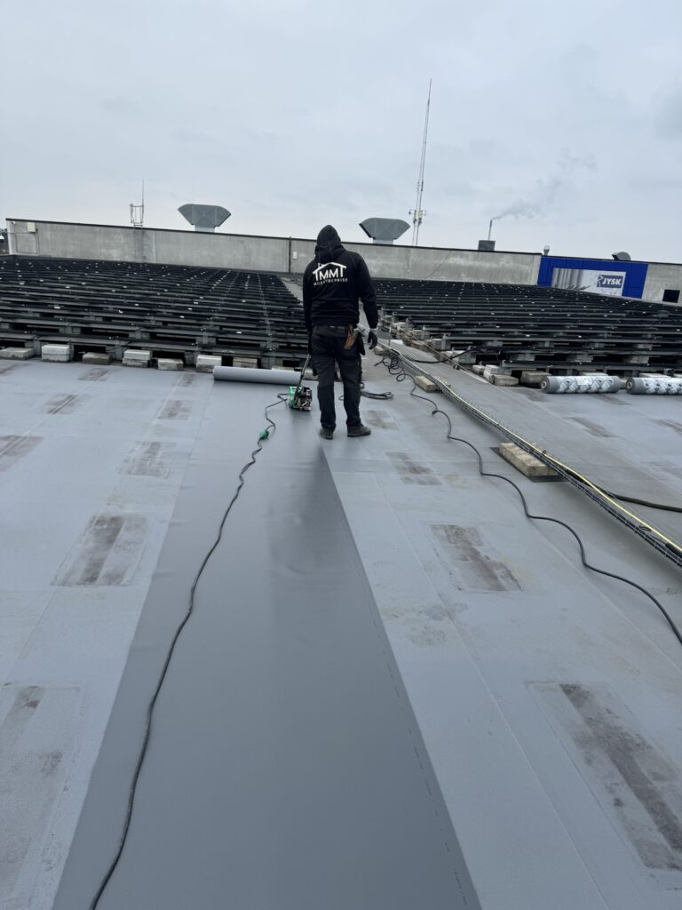 Håndværker arbejder på tagdækning med tagfolie