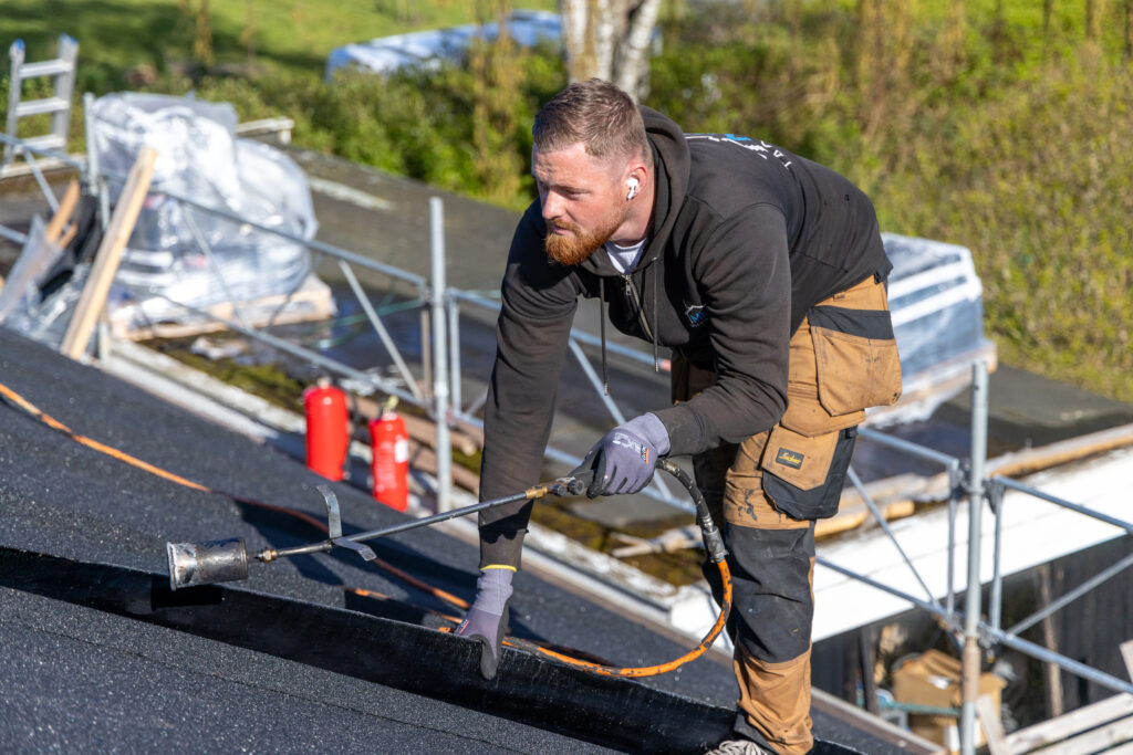 Tagdækker arbejder på tag med gasbrænder