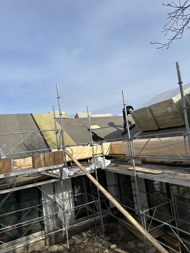 Tagrenovering på hus med stillads omkring bygningen