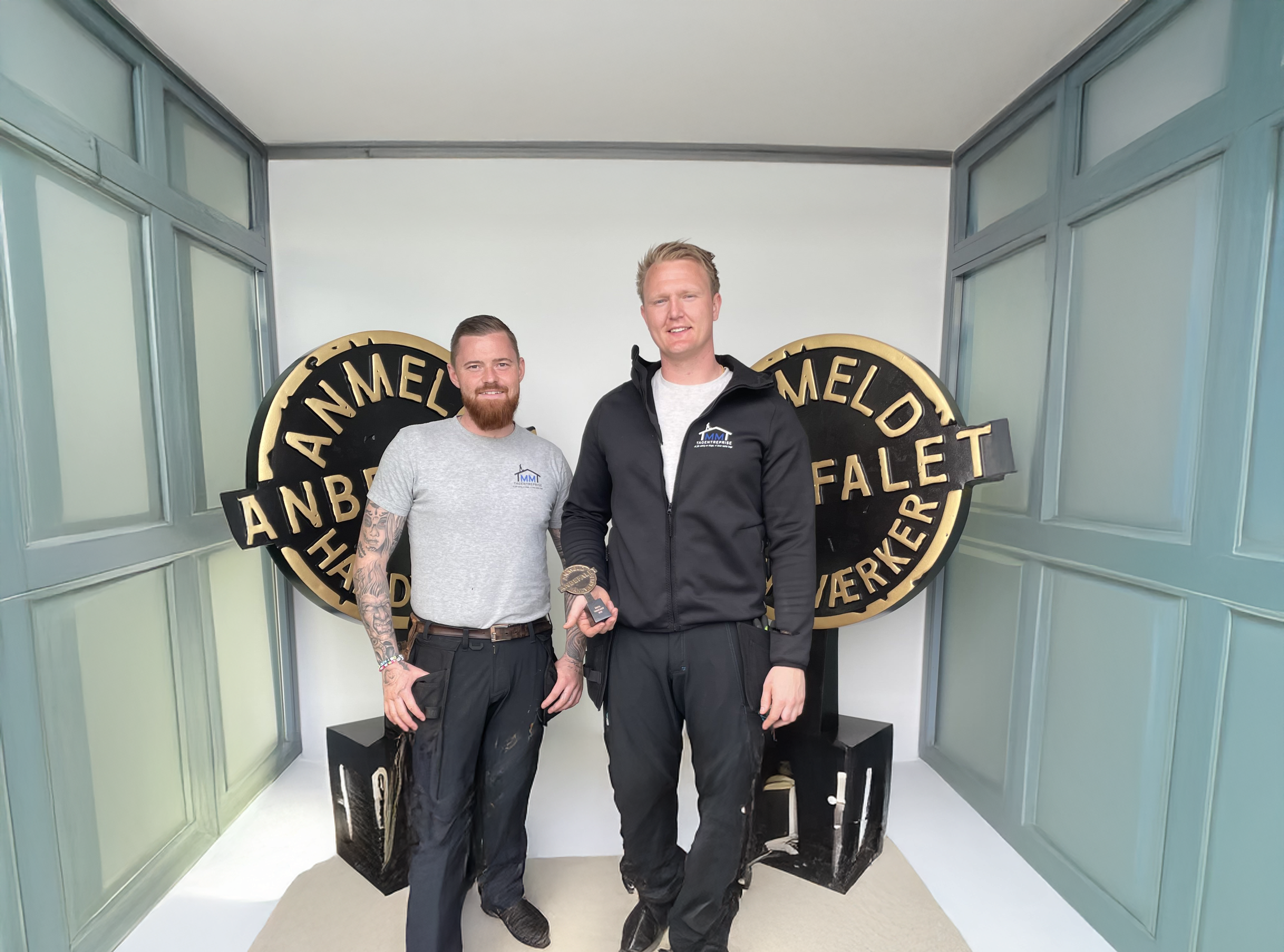 To håndværkere med pris foran Anmeld Håndværker logo