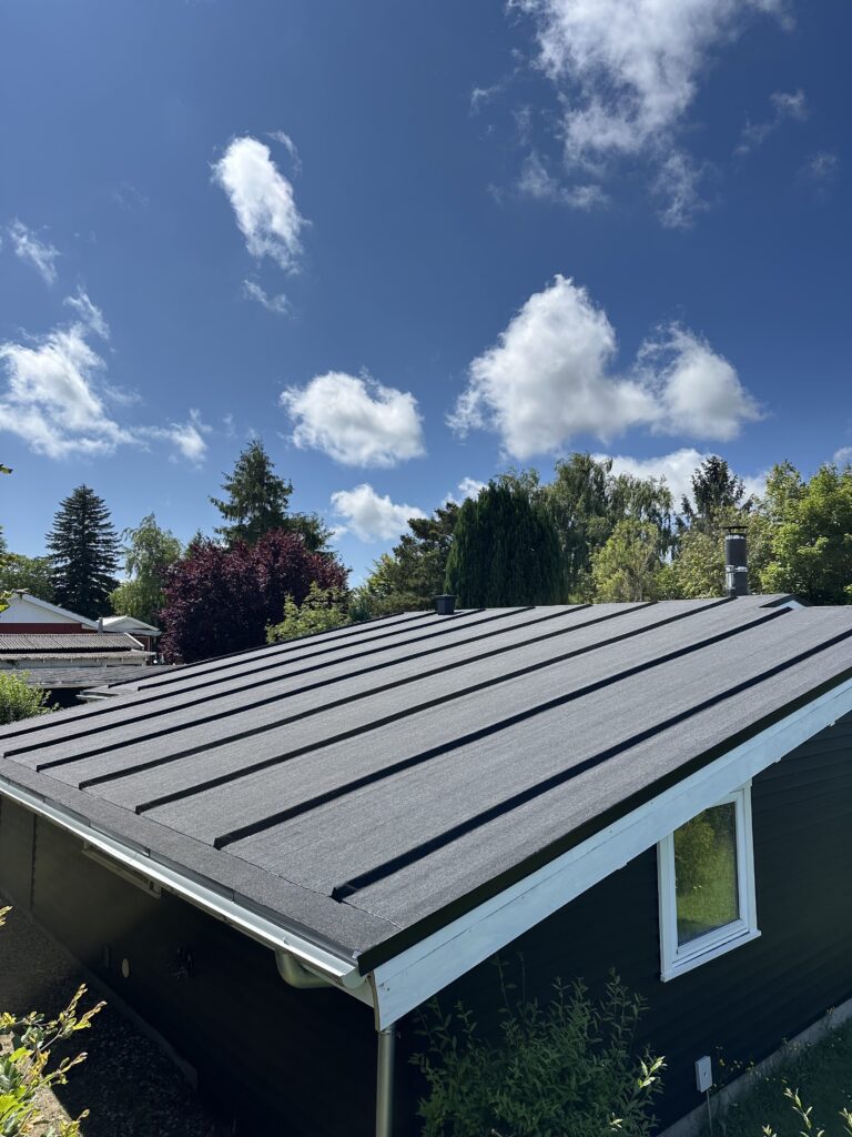 Moderne sort tag på hus under blå himmel